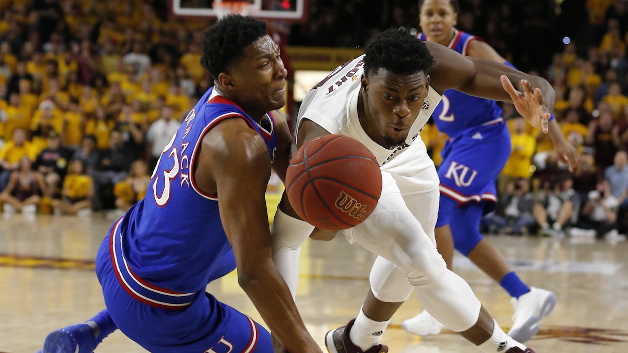 David McCormack (à gauche), de l'Université du Kansas, et Luguentz Dort, de l'Université Arizona State, tentent d'attraper le ballon.