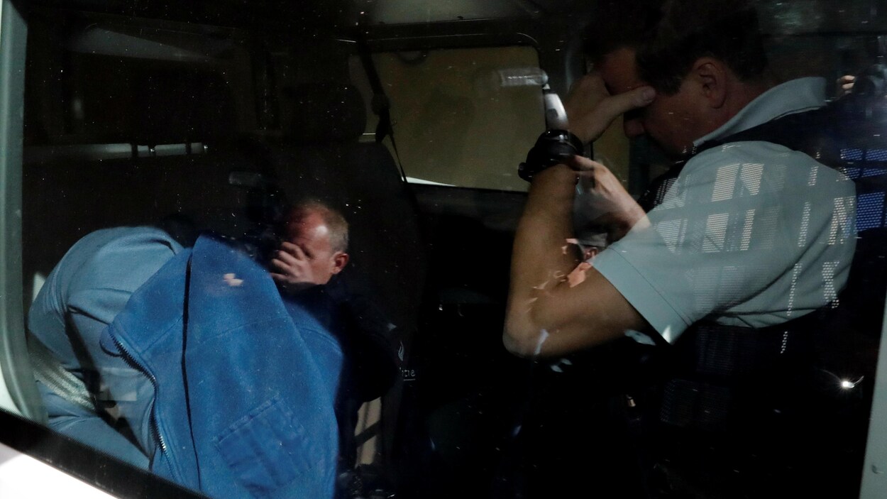 Un homme dans une fourgonnette, traqué par les photographes, se cache à l'aide de sa veste en quittant le palais de justice de Tongres, en Belgique. Un homme dans une fourgonnette, traqué par les photographes, se cache à l'aide de sa veste en quittant le palais de justice de Tongres, en Belgique.