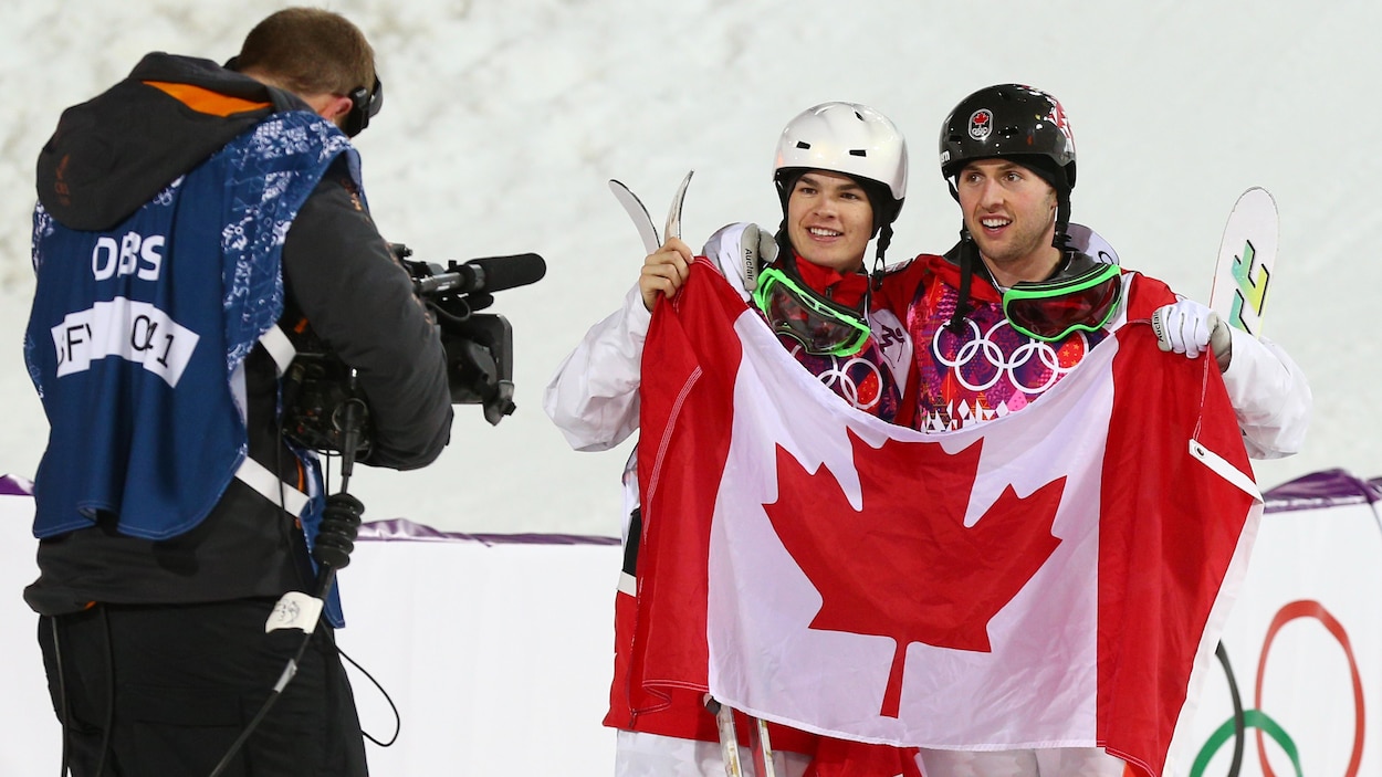 Deux skieurs devant le drapeau canadien