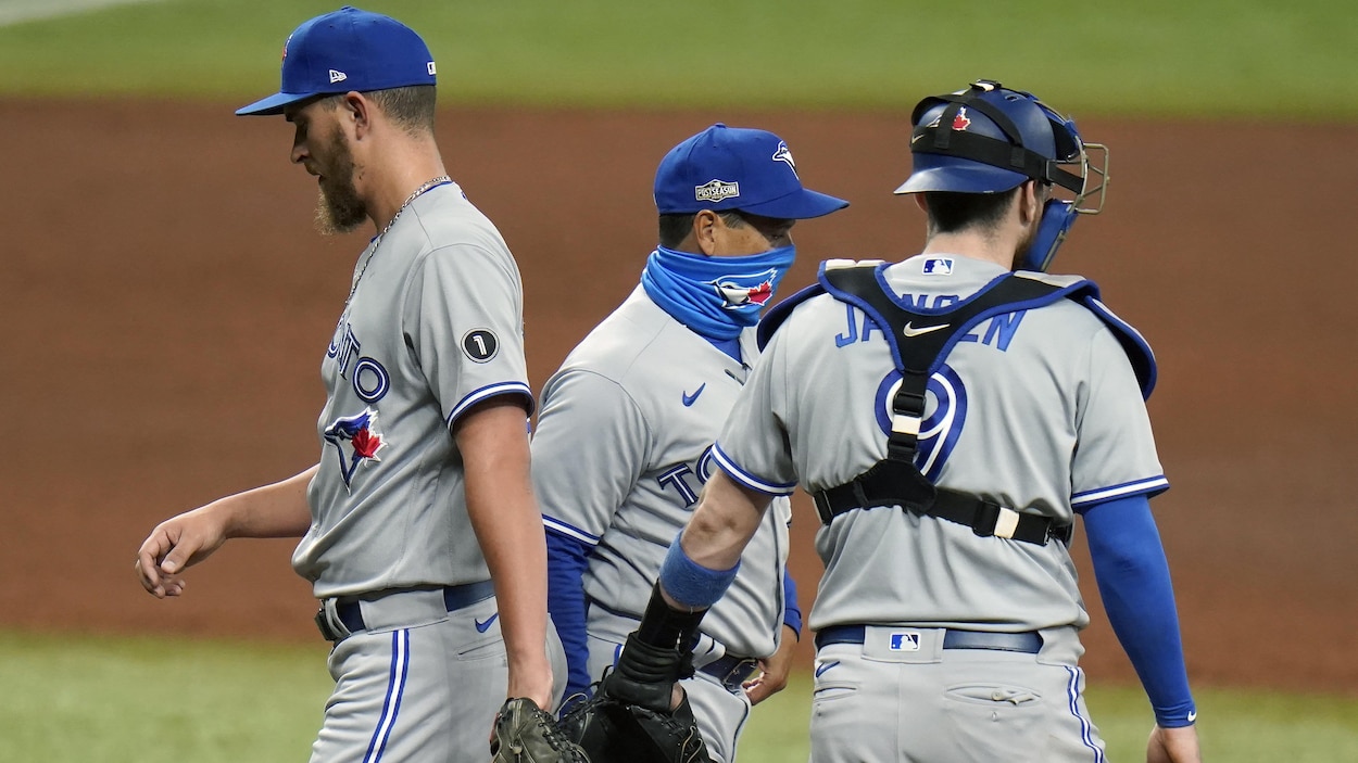 Un entraîneur de baseball marche sur le terrain de jeu.