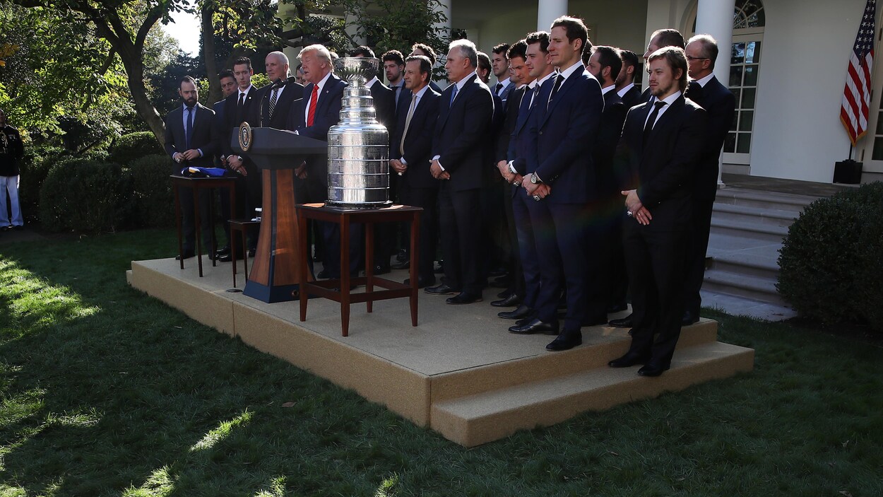 Les joueurs se tiennent sur une tribune, avec la coupe Stanley et le président américain Donald Trump, devant la Maison-Blanche.
