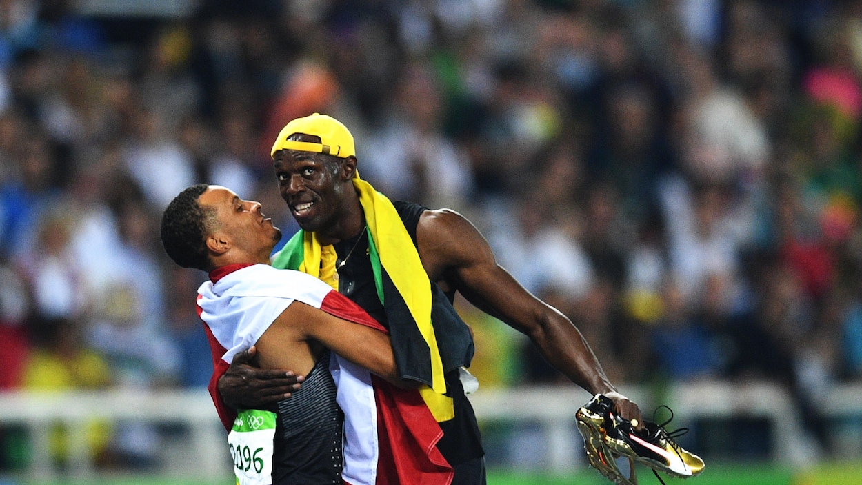 Le triple champion olympique du 100 m, le Jamaïcain Usain Bolt, enlace le Canadien Andre De Grasse (3e).