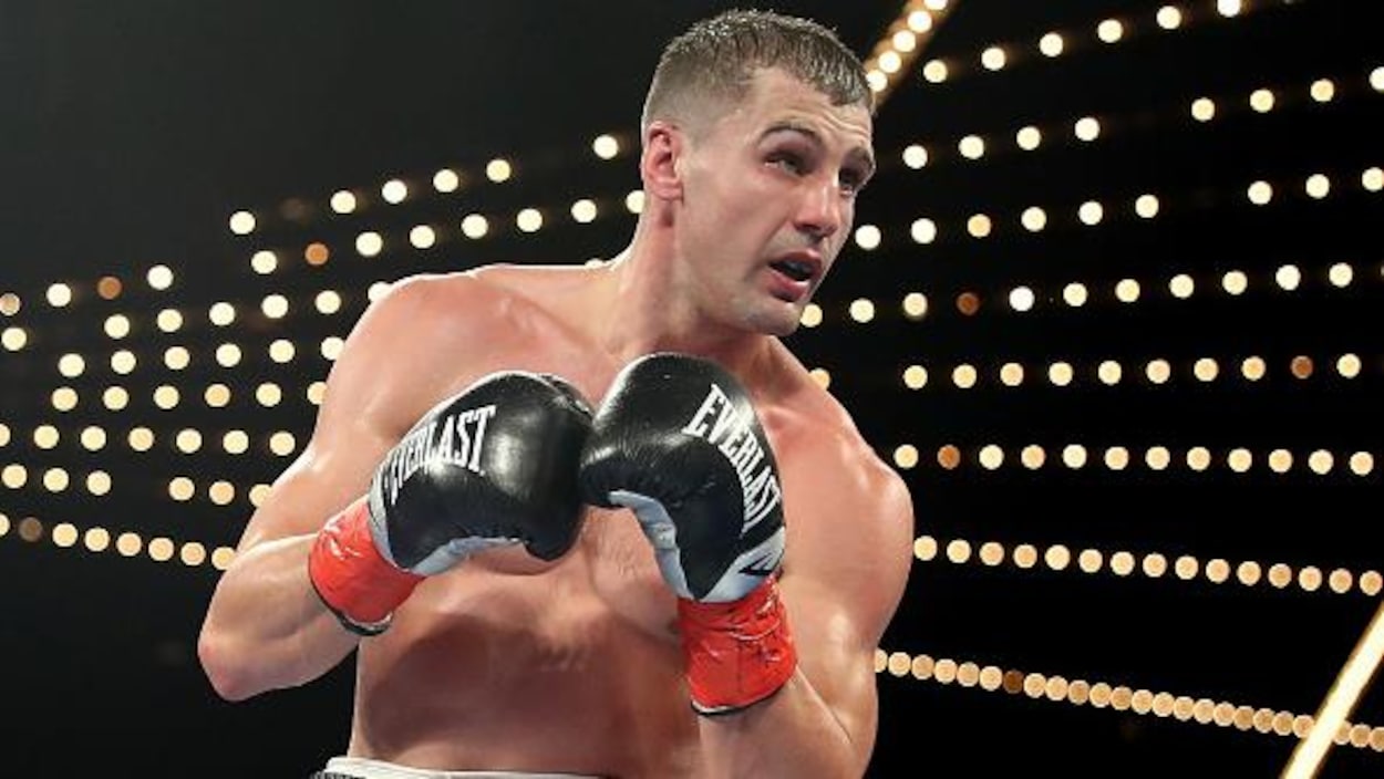 Il tient ses poings l'un contre l'autre dans le ring.