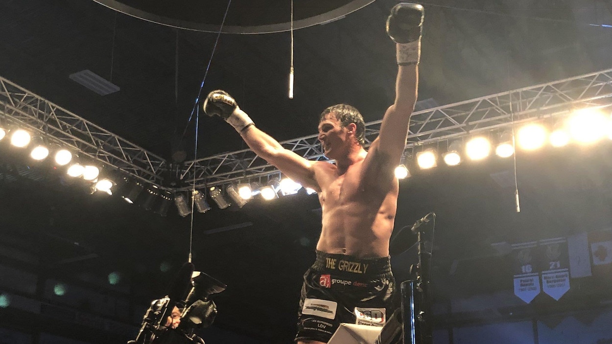 Il lève les bras au ciel pour célébrer sa victoire contre Dillon Carman.