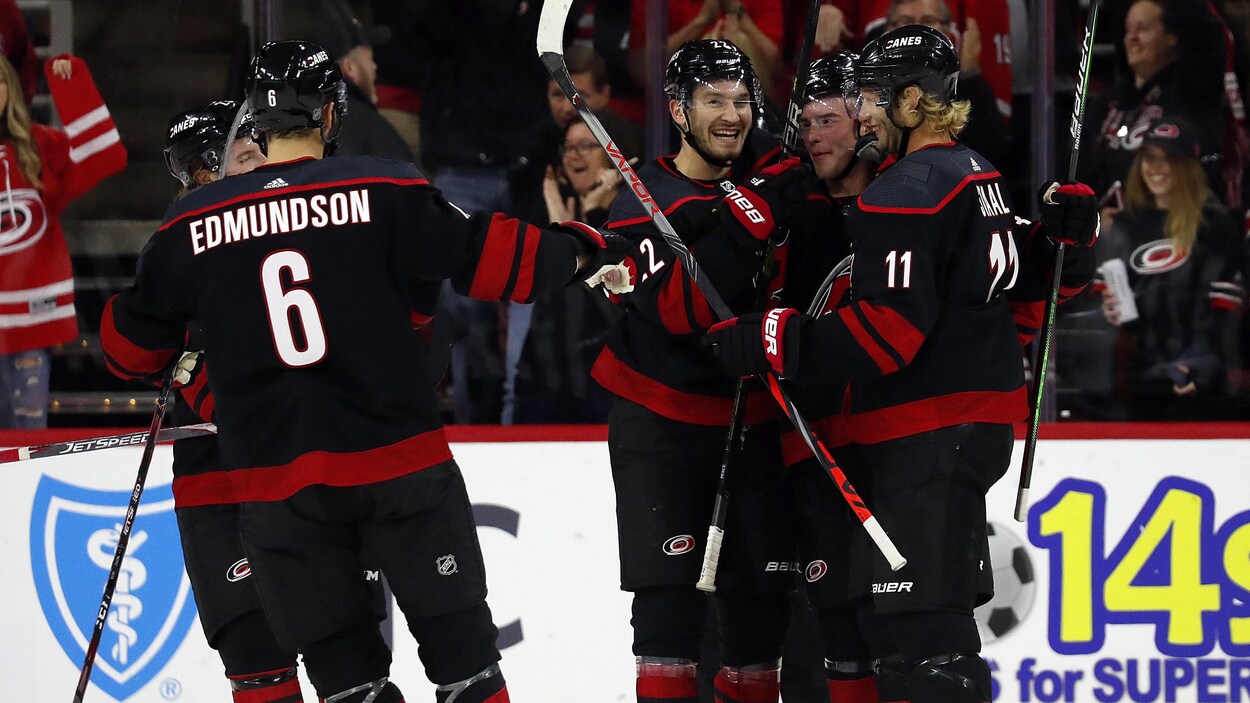 Brett Pesce (au centre) est entouré par ses coéquipiers après son but.