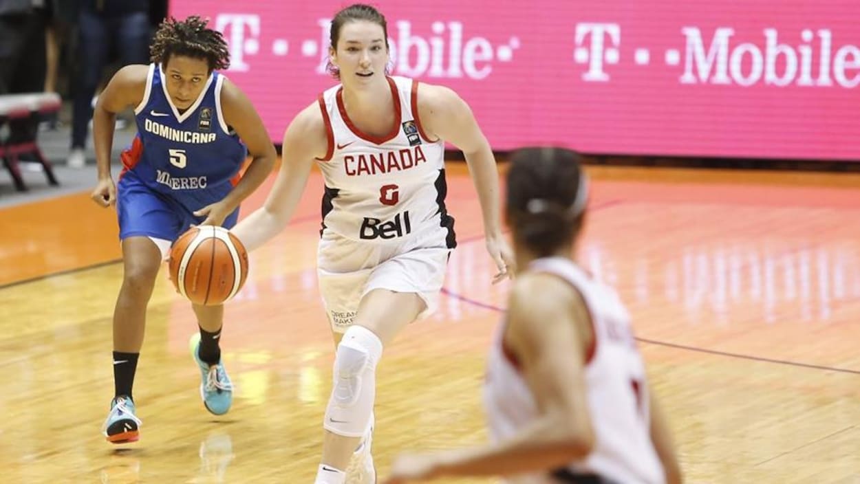 Elle court sur le terrain en dribblant avec le ballon.