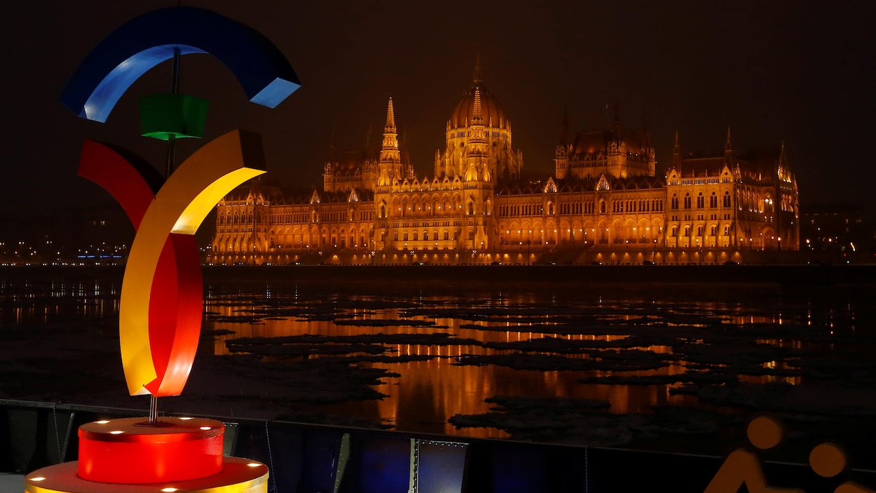 Le logo de la candidature olympique de Budapest avec, en arrière-plan, le parlement hongrois Le logo de la candidature olympique de Budapest avec, en arrière-plan, le parlement hongrois