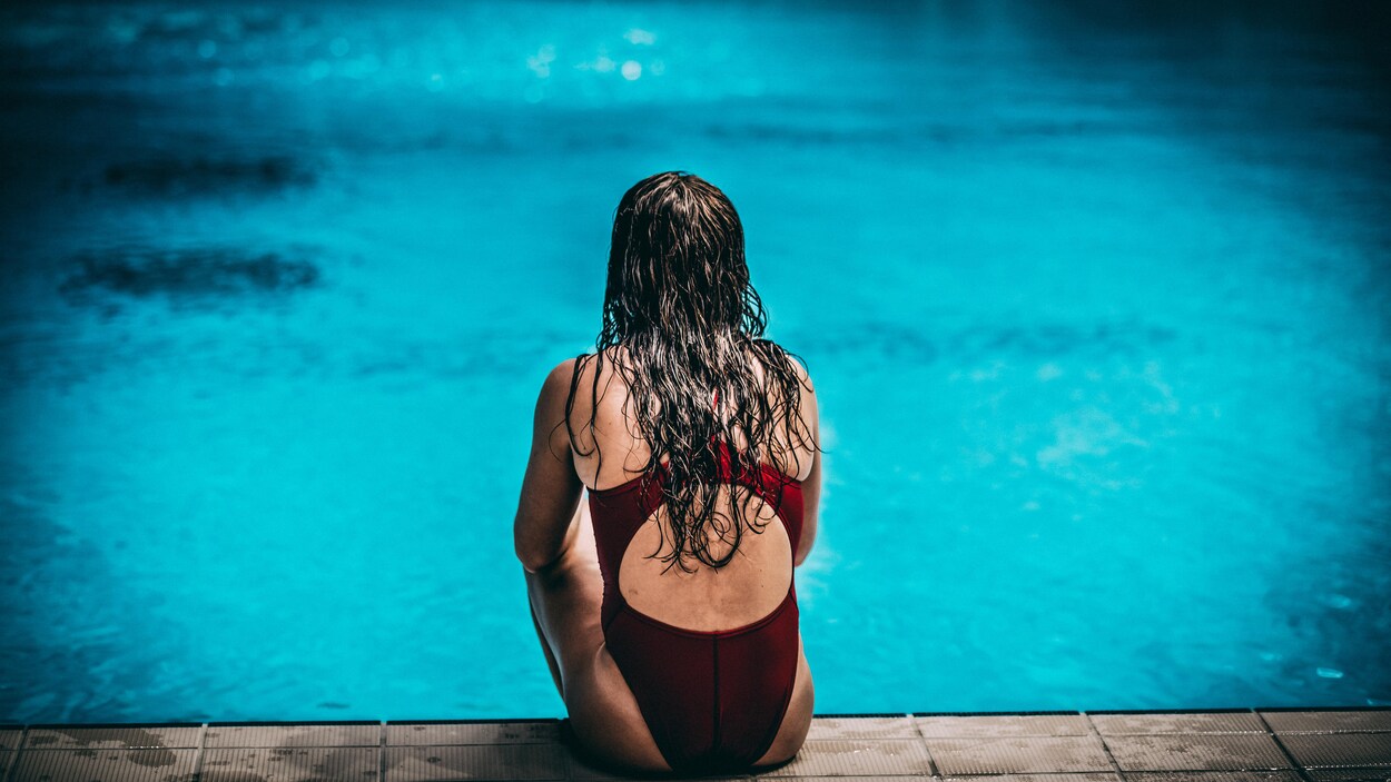 Caeli McKay est assise sur le bord du bassin de plongeon. Caeli McKay est assise sur le bord du bassin de plongeon.