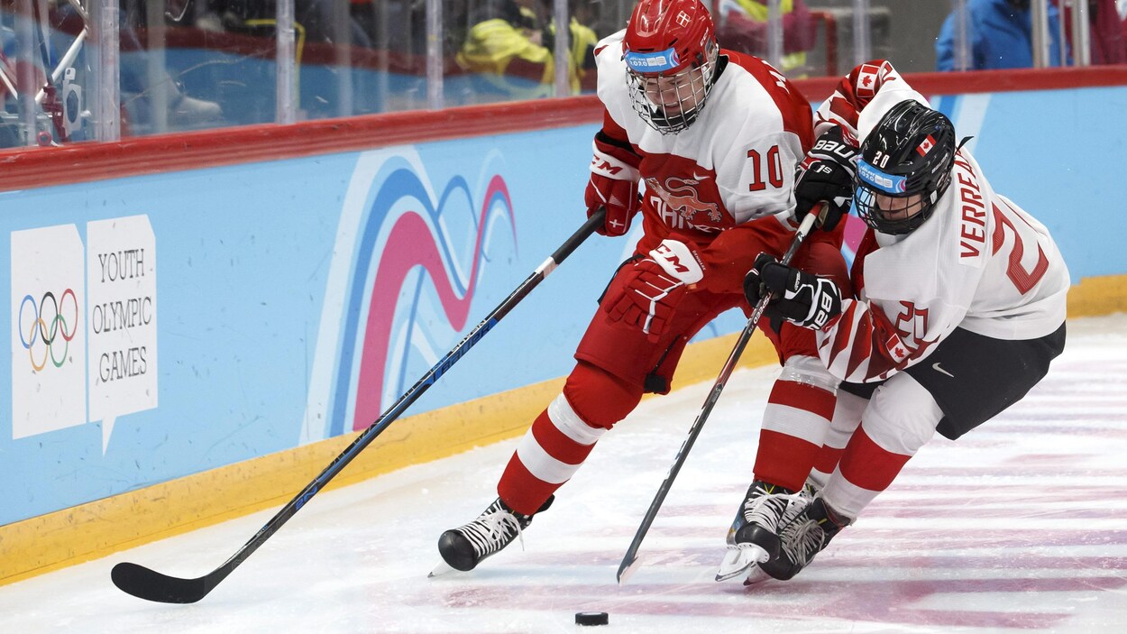 Le Danois Oliver Marklund lutte pour la rondelle avec le Canadien Antonin Verreault.