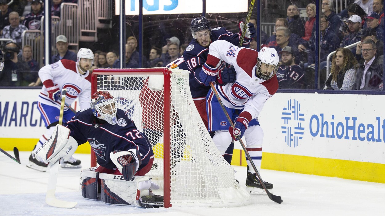 Pierre-Luc Dubois, des Blue Jackets, et Phillip Danault, du Canadien, luttent pour la rondelle.
