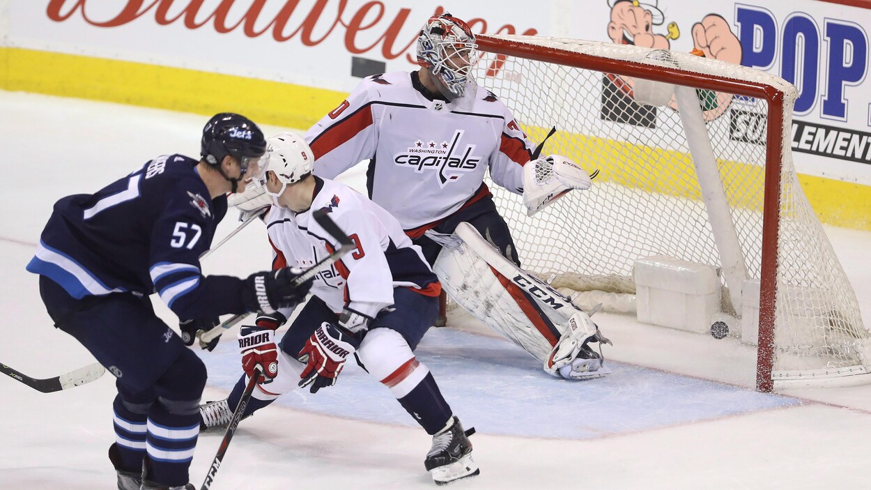 Tyler Myers regarde la rondelle qui traverse la rondelle, sous le regard impuissant de Dmtry Orlov, le défenseur des Capitals. Tyler Myers regarde la rondelle qui traverse la rondelle, sous le regard impuissant de Dmtry Orlov, le défenseur des Capitals.