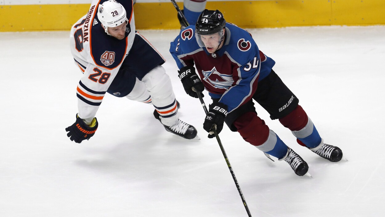 Carl Soderberg contrôle la rondelle, surveillé par Kyle Brodziak pendant un match entre les Oilers d'Edmonton et l'Avalanche du Colorado à Denver.