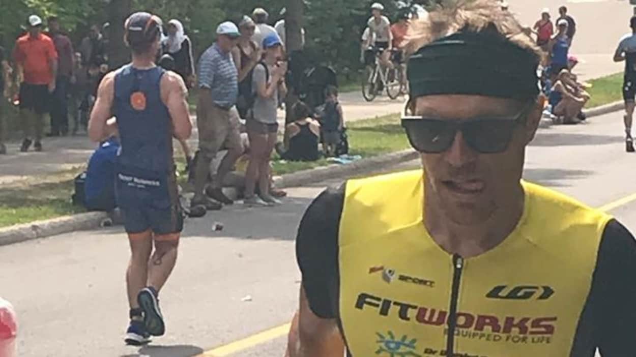 Cédric avec des lunettes fait de la course dans la rue.