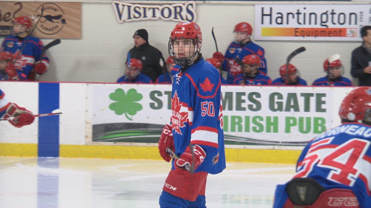 Cédrick est vêtu de son équipement de hockey. Il attend la prochaine séquence de jeu lors d'une pause. Il porte le numéro 50.