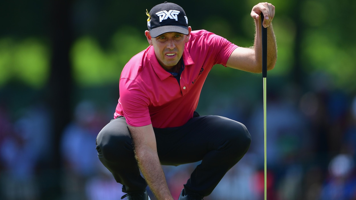 Charl Schwartzel s'accroupit derrière sa balle avant un coup roulé. Charl Schwartzel s'accroupit derrière sa balle avant un coup roulé.