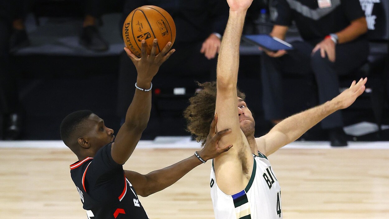 Chris Boucher tente un tir devant le joueurs des Bucks Robin Lopez.