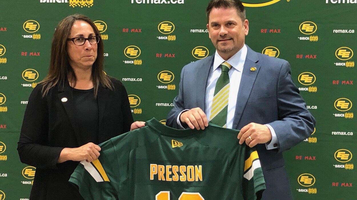 La présidente du conseil d'administration des Eskimos, Janice Agrios, remet un chandail de la formation au nouveau président Chris Presson.