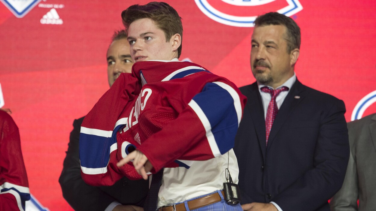Cole Caufield¸enfile un chandail du Canadien de Montréal.