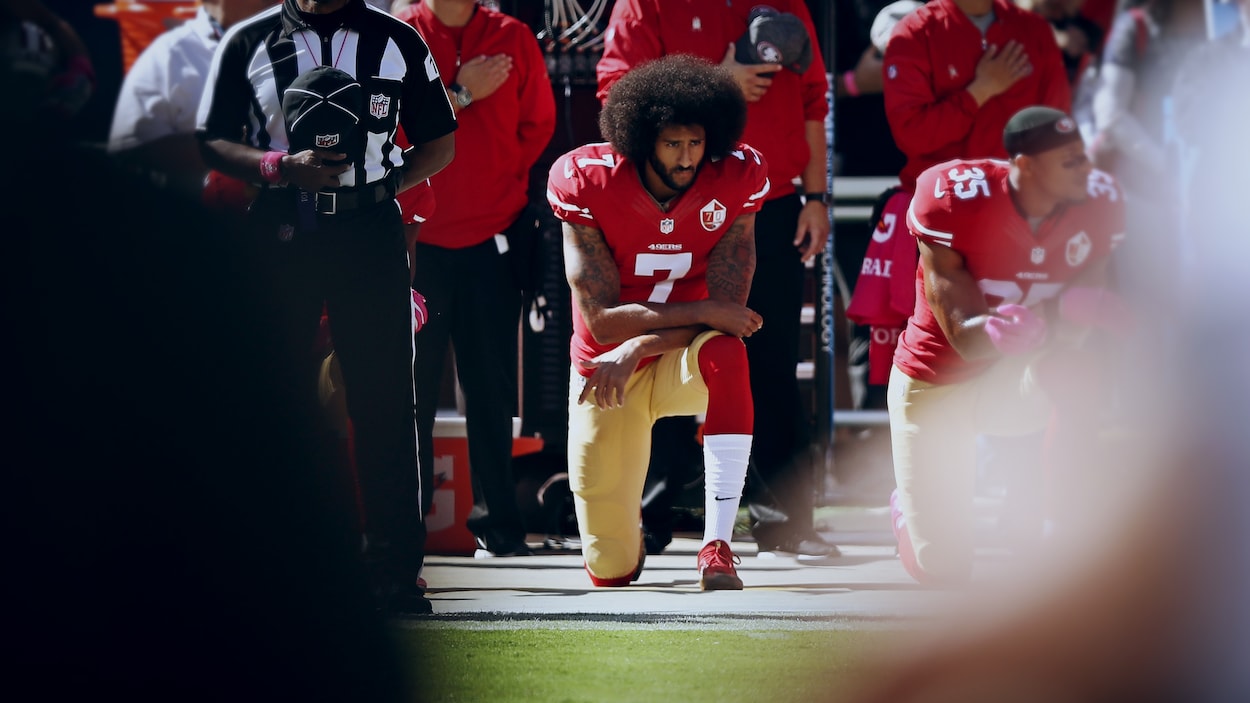 Colin Kaepernick est immobile, un genou au sol.