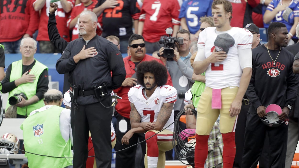 Colin Kaepernick, à genou lors de l'hymne national d'avant-match. Colin Kaepernick, à genou lors de l'hymne national d'avant-match.