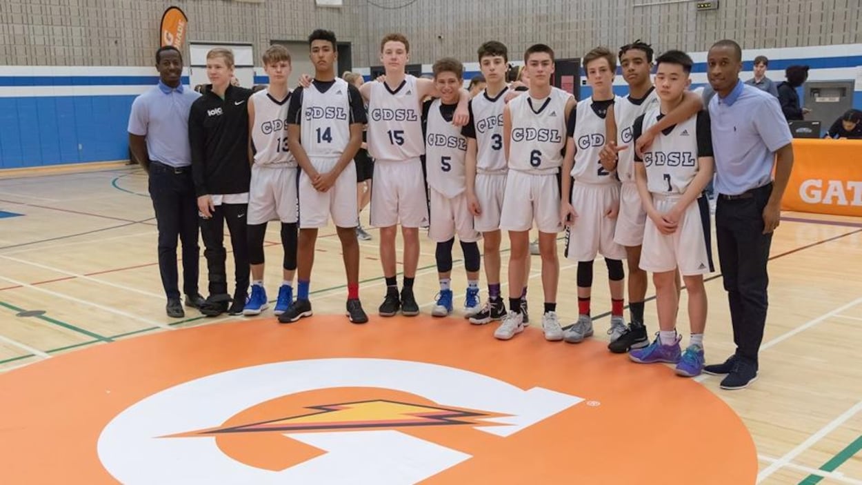 Des joueurs de basketball posent ensemble sur un terrain.