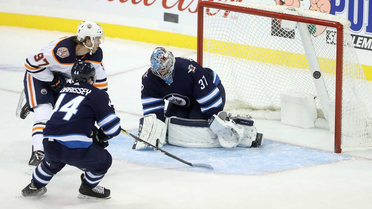 Le centre des Oilers Connor McDavid marque son premier but du match contre les Jets de Winnipeg. Le centre des Oilers Connor McDavid marque son premier but du match contre les Jets de Winnipeg.