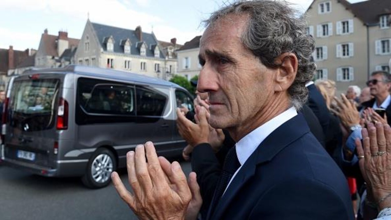 Un homme triste assiste à des funérailles.