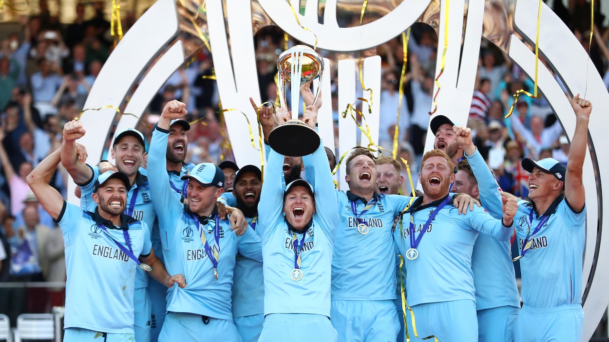 Le capitaine anglais Eoin Morgan, entouré de ses coéquipiers, soulève le trophée de la Coupe du monde de cricket après la victoire des siens en finale.