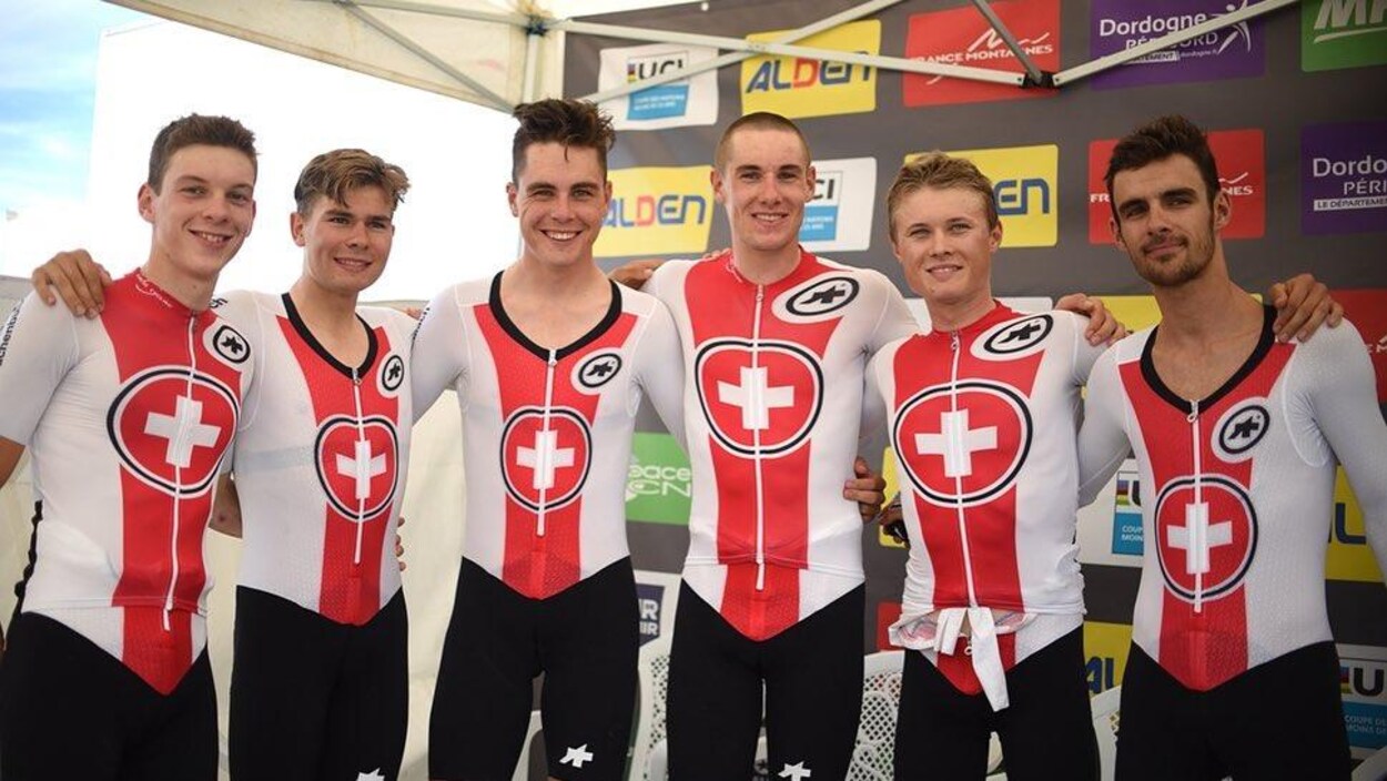 Les six cyclistes se tiennent par les épaules après leur victoire.