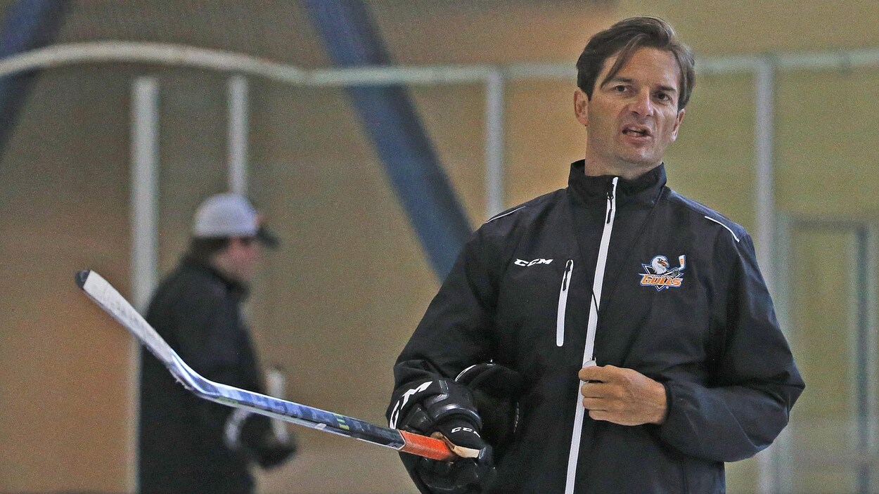 Il tient un hockey dans sa main droite à l'entraînement.