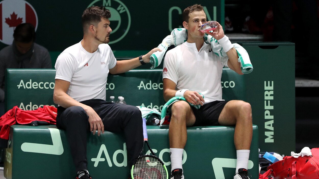 Un joueur s'hydrate pendant qu'il reçoit les conseils de son capitaine.