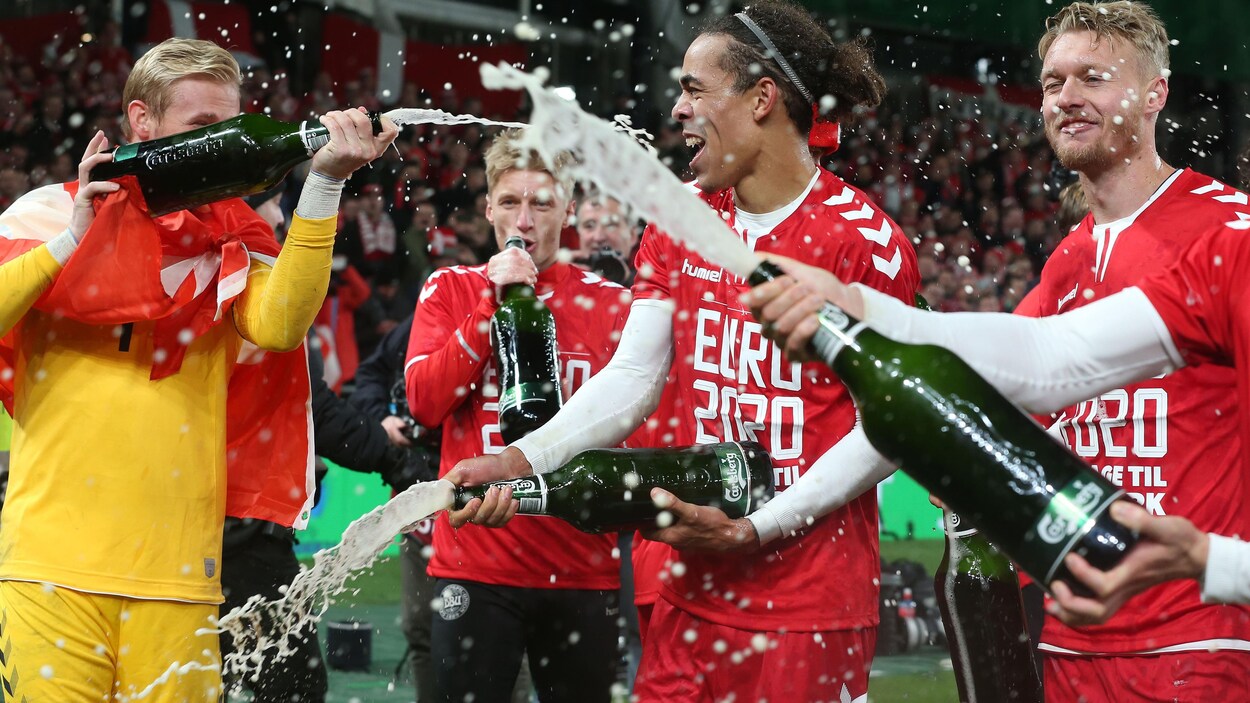 Ils s'aspergent avec des bouteilles de bière Carlsberg.