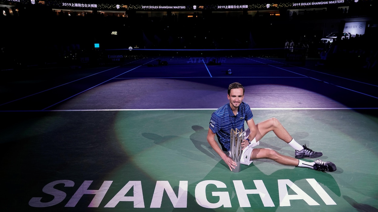 Il pose avec le trophée du gagnant sur le court principal du tournoi de Shanghai.