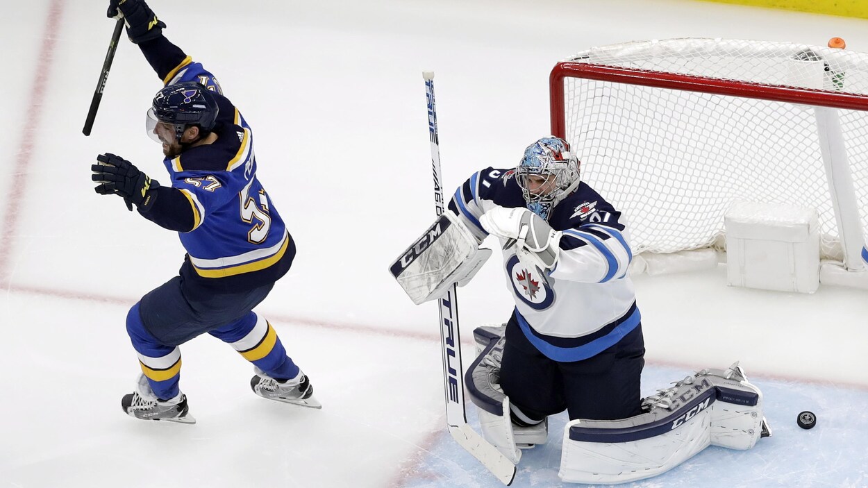 David Perron (no 57) et Connor Hellebuyck (no 37)
