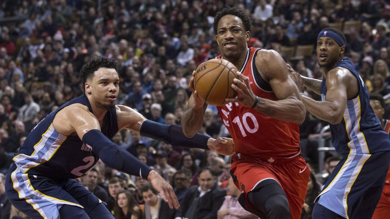 Ballon en mains, le garde des Raptors DeMar DeRozan fonce vers le panier devant Dillon Brooks. Ballon en mains, le garde des Raptors DeMar DeRozan fonce vers le panier devant Dillon Brooks.