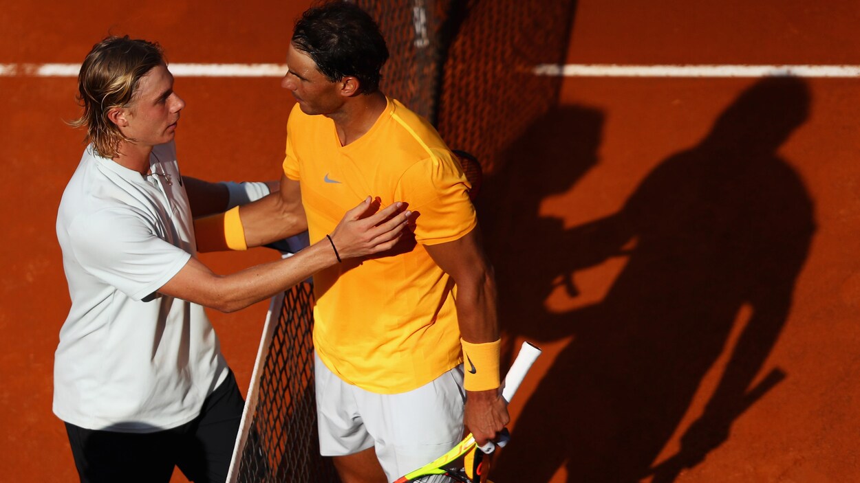 Denis Shapovalov félicite Rafael Nadal près du filet. Denis Shapovalov félicite Rafael Nadal près du filet.
