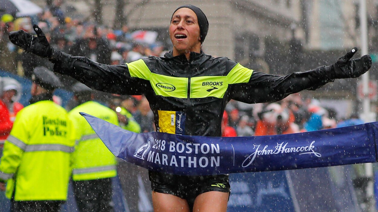 L'Américaine Desiree Linden croise le fil d'arrivée sous la pluie. L'Américaine Desiree Linden croise le fil d'arrivée sous la pluie.
