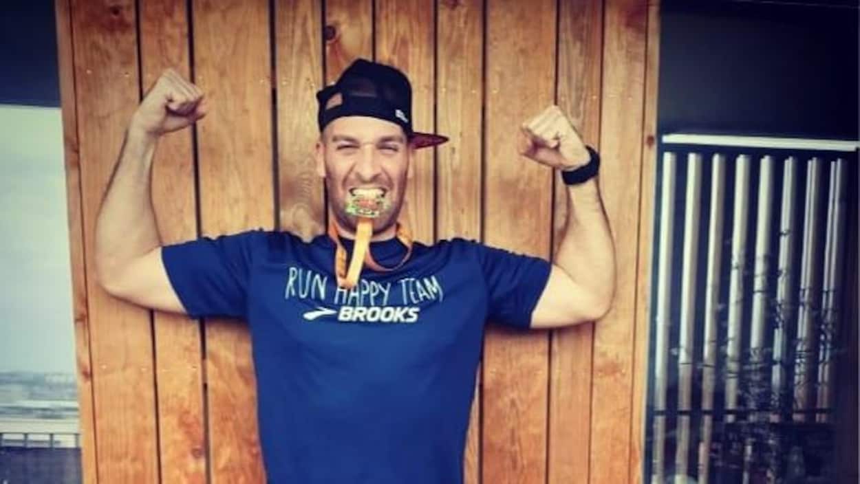 Il a les bras en l'air et mord dans une médaille.