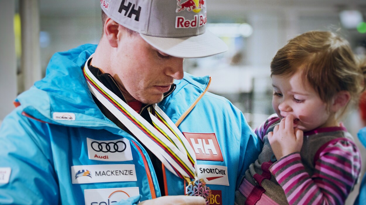 Erik Guay montre ses médailles à sa fille Marlo à son retour des mondiaux de ski alpin, en février 2017. Erik Guay montre ses médailles à sa fille Marlo à son retour des mondiaux de ski alpin, en février 2017.