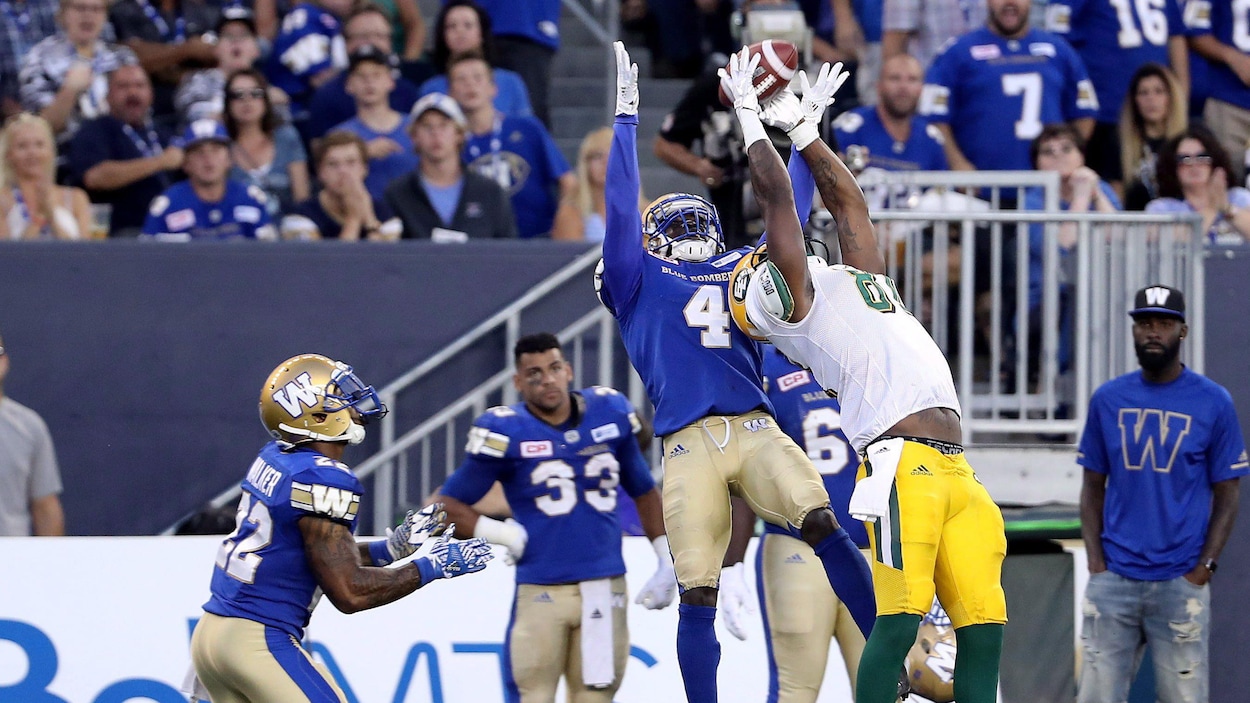 Bryant Mitchell des Eskimos capte une passe, même s'il est surveillé par Brian Walker (22) et Roc Carmichael (4) des Blue Bombers. Bryant Mitchell des Eskimos capte une passe, même s'il est surveillé par Brian Walker (22) et Roc Carmichael (4) des Blue Bombers.