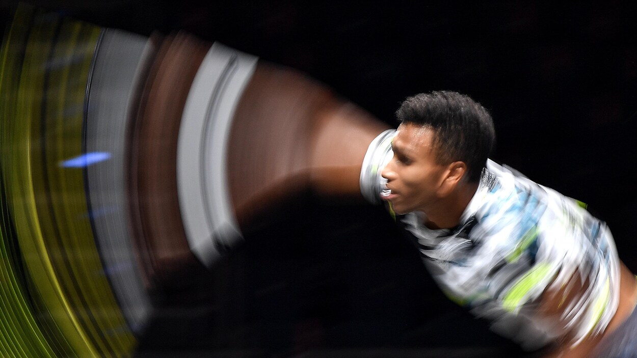 Le mouvement flou d'une raquette d'un joueur qui fait un service au tennis.