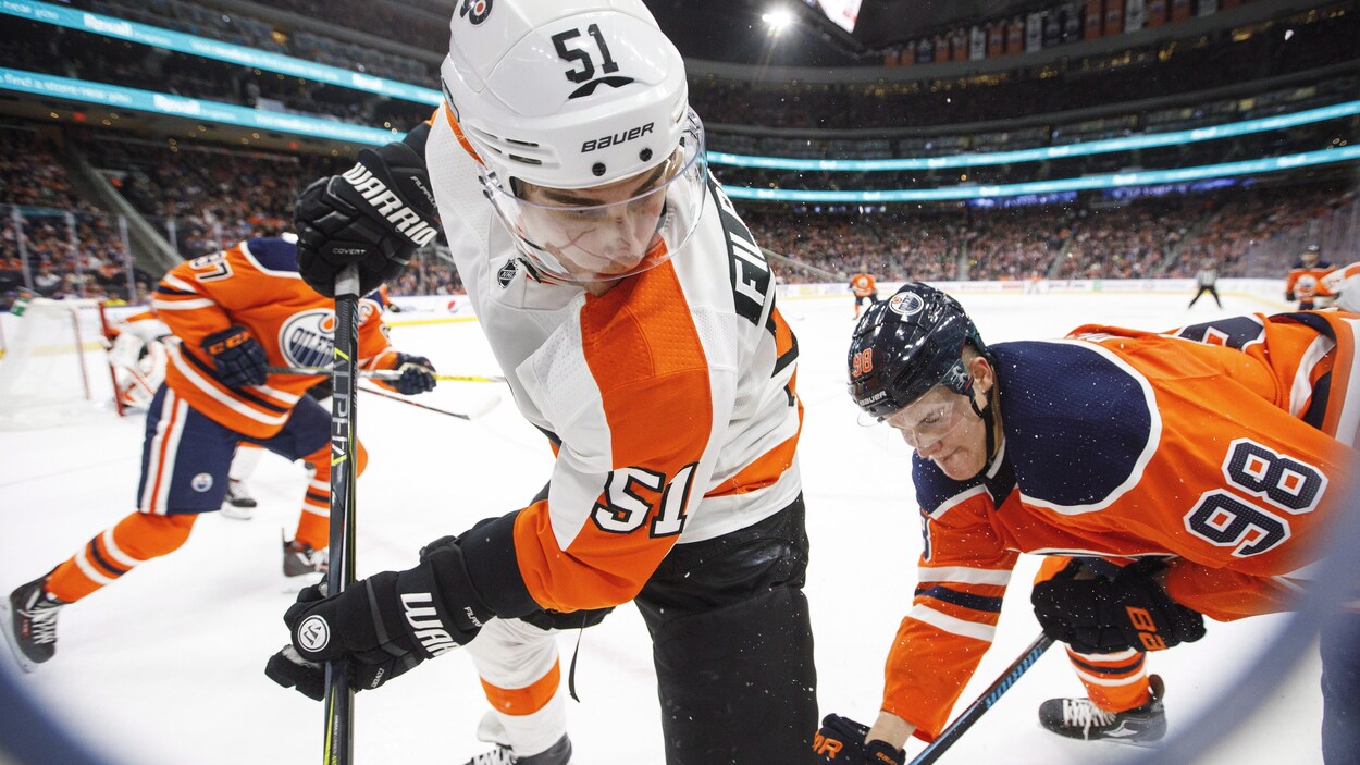 Valteri Filppula des Flyers bataille avec deux joueurs des Oilers pour l'obtention de la rondelle Valteri Filppula des Flyers bataille avec deux joueurs des Oilers pour l'obtention de la rondelle