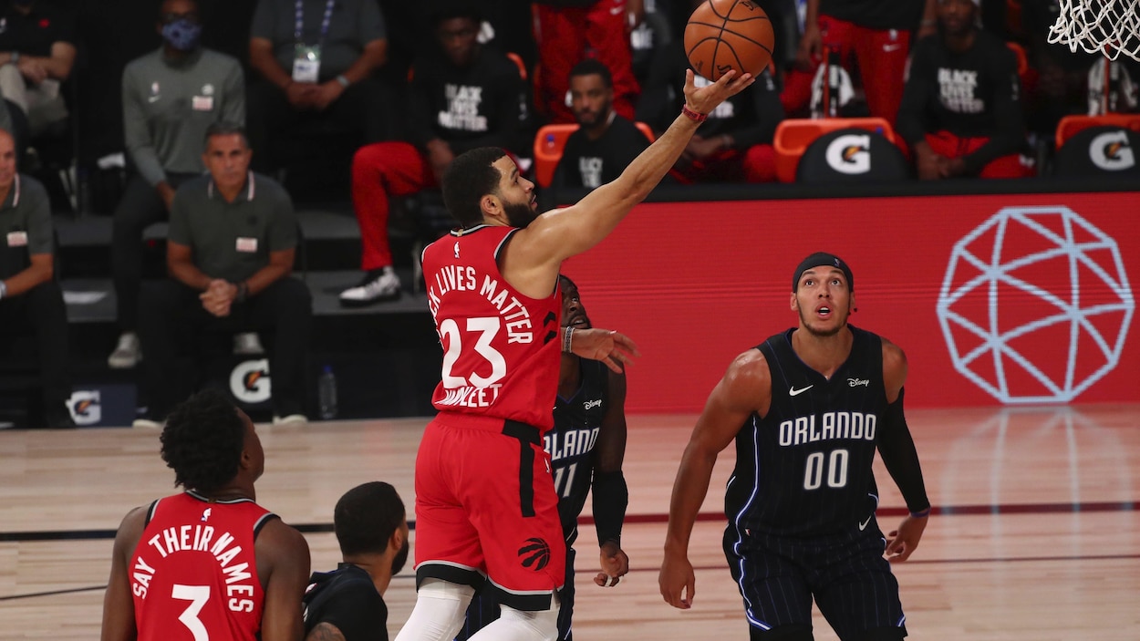 Un joueur de basketball s'élance vers le panier avec le ballon en main.