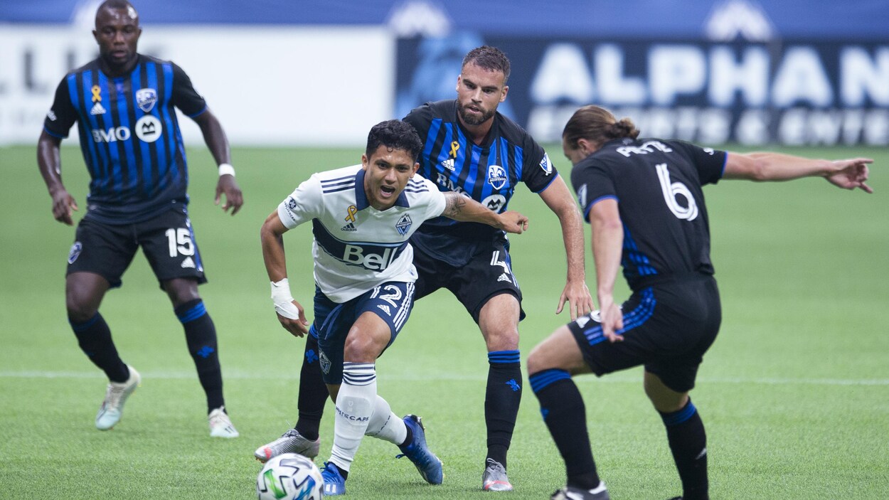 Montero a le ballon à ses pieds, tandis que Piette et Rudy Camacho tentent de le bloquer.