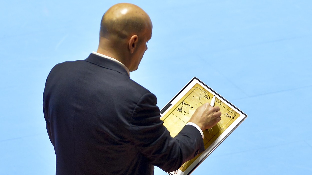 L'entraîneur pose son crayon sur son tableau.