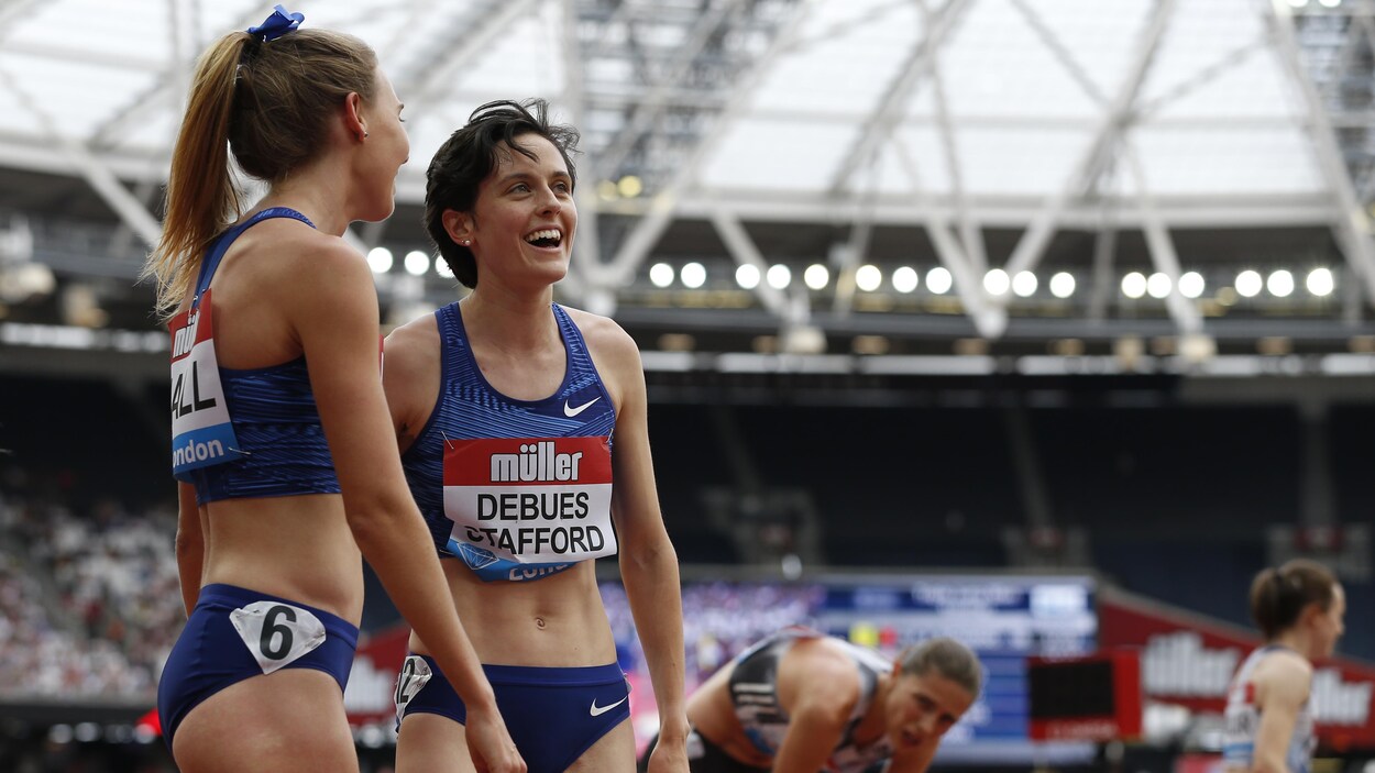 Elle sourit avec une adversaire après sa course.