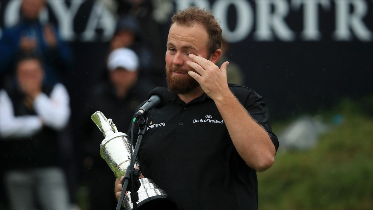 Il essuie une larme avec son trophée dans les mains.