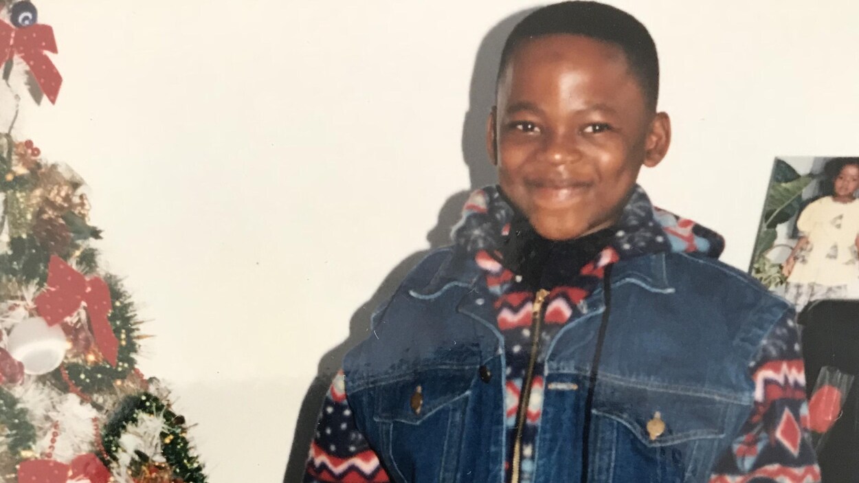 Le jeune Hénoc Muamba pose à côté d'un arbre de Noël. Le jeune Hénoc Muamba pose à côté d'un arbre de Noël.