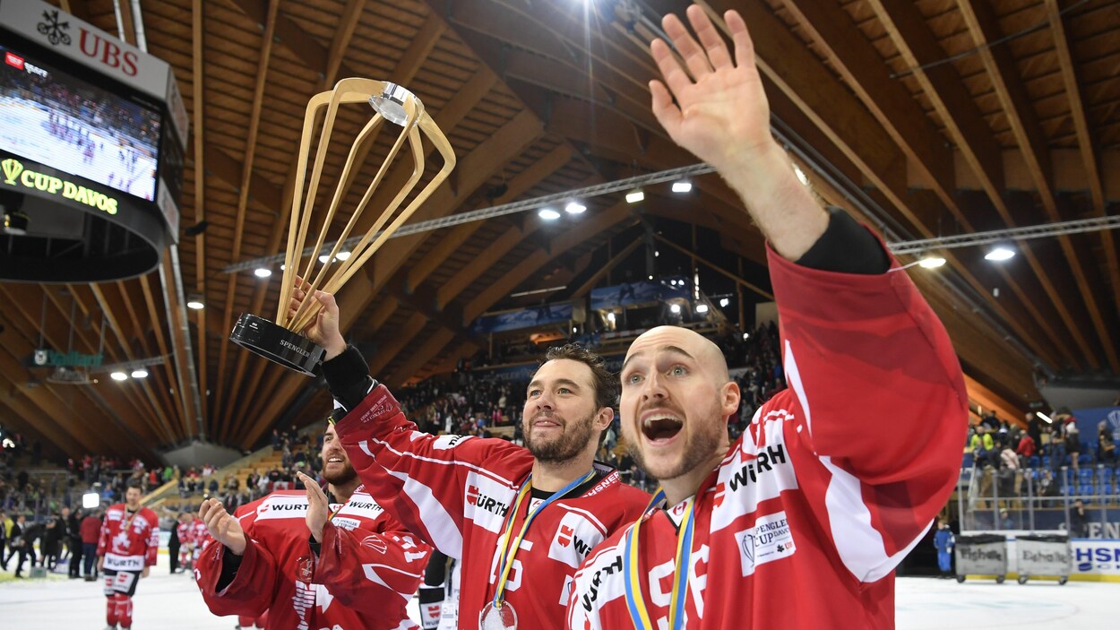 Le capitaine du Canada, Maxim Noreau (à droite) et Pierre-Alexandre Parenteau célèbrent avec la coupe Spengler. Le capitaine du Canada, Maxim Noreau (à droite) et Pierre-Alexandre Parenteau célèbrent avec la coupe Spengler.
