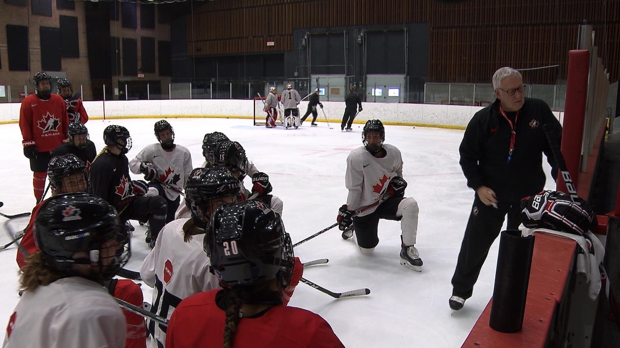 L'entraîneur donne des directives aux hockeyeuses canadiennes.